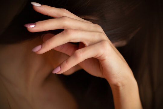 white woman hand covers her face. Cropped image. Concept of loneliness, sadness, fear