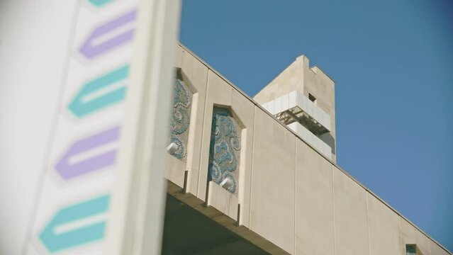 Tatar patterns on concrete facade of public building in city under blue sky low angle shot. Urban architecture style