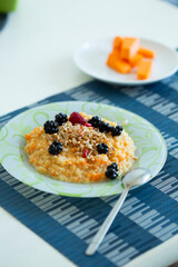 Cup of freshly brewed pumpkin porridge with berries on the table. healthy food idea