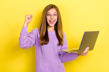 Photo of excited youngster crazy positive schoolgirl wear purple sweater hold new apple macbook...
