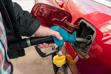 A man hand holding pump filling gasoline. Pumping petrol into the tank. A car refuel on gas station