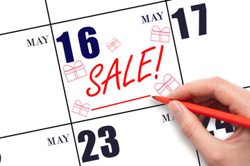 Hand writing text SALE and drawing gift boxes on calendar date May 16. Shopping Reminder