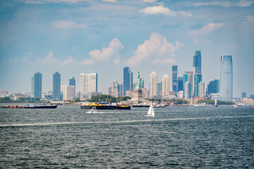Fototapeta premium Jersey City, NJ. USA - August 20, 2022: Skyline of Jersey City with the Statue of Liberty from the Staten Island ferry