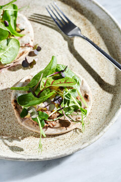Rye tacos with duck confit, sliced pear and assorted microgreens