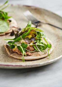 Rye tacos with duck confit, sliced pear and assorted microgreens