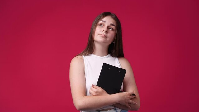 4k video of lovely woman thinking what to write down isolated over red background.