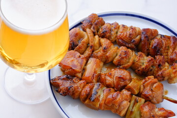 炭火焼の焼き鳥（タレ）をつまみにビールを飲む