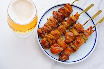 炭火焼の焼き鳥（タレ）をつまみにビールを飲む