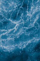 Dark blue sea surface with waves, splash and bubbles