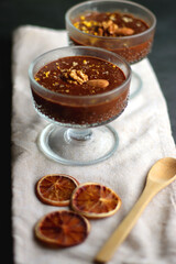 Bowl of homemade chocolate chia pudding, made with dark chocolate, chia seeds, orange juice and plant based milk. Selective focus.