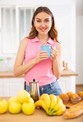 Woman holding coffee pot and pouring fresh coffee into mug. Woman having breakfast with hot drink at home