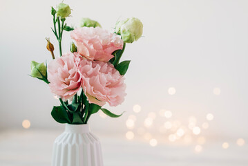 Beautiful pink bouquet of flowers in the vase on the table. Cozy home decoration and festive decor