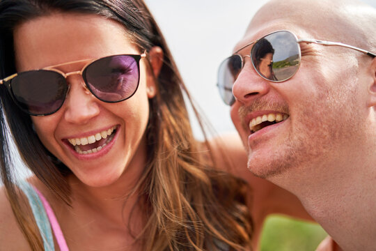 Close up happy couple in sunglasses laughing