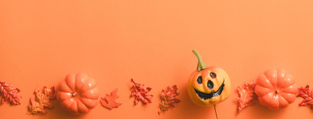 Obraz na płótnie Canvas Creative Halloween design concept background with pumpkin, autumn leaves and copy space.