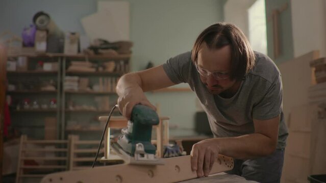Grinding machine makes wooden polishing of bar plank.