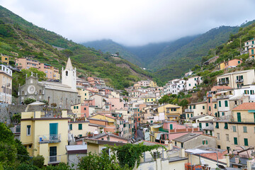 Fototapeta na wymiar View of the colorful houses along the coastline of Cinque Terre area in Riomaggiore, Italy