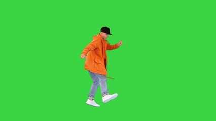 Caucasian man in orange raincoat dancing while walking on a Green Screen, Chroma Key.