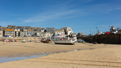 Fototapeta na wymiar St Ives Harbour at low tide with fishing boats waiting for high tide, Corwall, UK 27 August 2022
