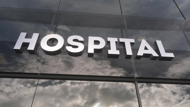 Hospital sign on a modern glass skyscraper. Hospital glass building. Health, clinic, emergency, healthcare and medical concept