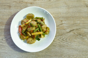 spicy fried slice fresh coconut shoot with fish ball in curry on plate