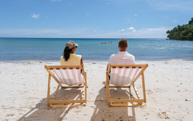 Men and women relaxing on the beach in a colorful beach chair, a Beach vacation Concept with a...