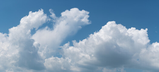 Naklejka na ściany i meble Bright clouds grow upward on blue sky, panoramic landscape