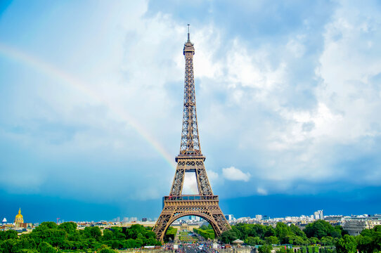 Eiffel Tower in Paris against the blue sky and rainbow. Landscape of a beautiful European city in France, tourism and travel in a romantic place.