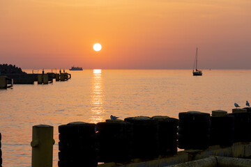 Sonnenuntergang über dem Meer an der Ostsee in Kolberg, Hafen, Polen.
Sommer 2022 - obrazy, fototapety, plakaty