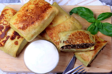 Traditional russian pancakes or blini with curd. Pancakes filled with minced heart or meat
