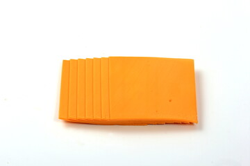 Orange cheddar cheese slices isolated on white