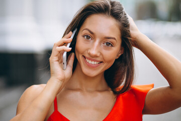Fototapeta premium Portrait of beautiful woman smiling and using phone