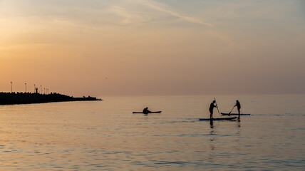 Schwimmen auf einem Stend up Paddle  bei Sonnenuntergang.
Kolberg, Baltic, Polen - Sommer 2022