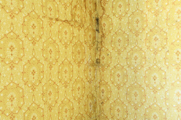 Old wallpaper on the wall. Old wallpaper for texture or background.