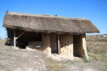 Fototapeta na wymiar old fashioned rural traditional construction with reed house top blue painted made of wood or clay