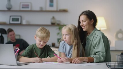 A young mother and two children, a boy and a girl, are doing homework together looking at the laptop screen. Remote education tutoring
