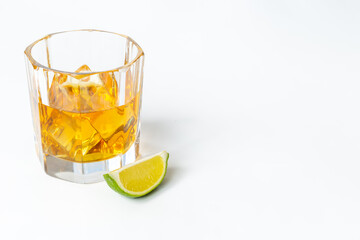 Golden whiskey in glass with ice. Strong alcohol background