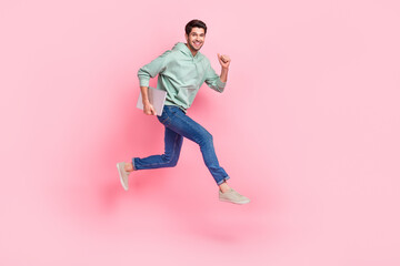 Fototapeta na wymiar Full length photo of overjoyed man wear trendy clothes move empty space hurry work business meeting isolated on pink color background