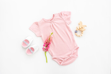 Baby girl bodysuit with toys and accessories, flat lay