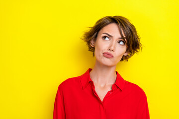 Portrait of thoughtful girlish cute suspicious woman bob hairstyle dressed red shirt look empty space isolated on yellow color background