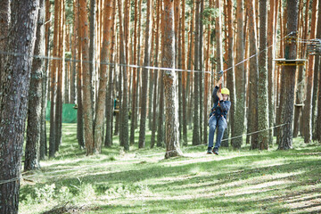 Child riding zipline in forest