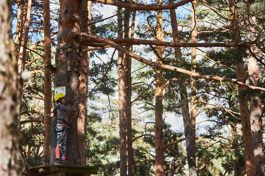 Kid on rope course in forest