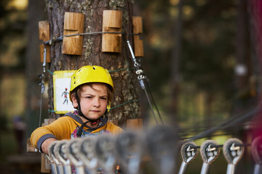 Boy on rope bridge in adventure park