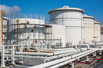 Obraz premium Saraburi, Thailand - October 5, 2022: Worker male assembly in progress storage new tank oil inspection pipeline scaffolding