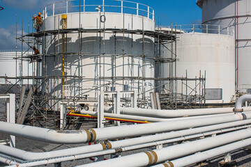 Worker male assembly in progress storage new tank  oil inspection pipeline scaffolding