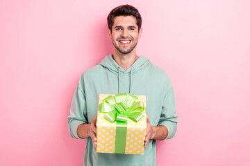 Photo of satisfied glad person toothy smile arms hold giftbox isolated on pink color background