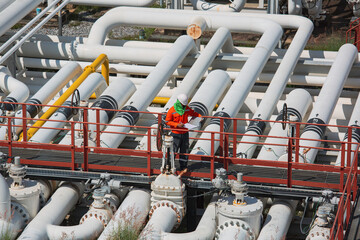 Male worker inspection at steel long pipes and pipe elbow valve in station oil factory during refinery valve of visual check record pipeline oil