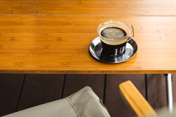 Cup of hot coffee isolated on wooden table outdoor.