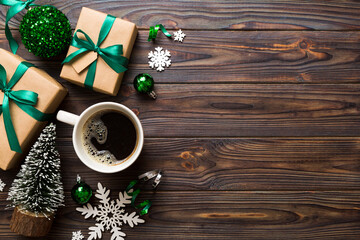 Delicious fresh festive morning coffee in a ceramic cup with little wrapped gifts, ornament and...