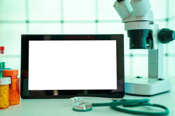 computer tablet screen with blank space for text next to microscope in laboratory