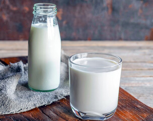 .Bottles and milk glasses on a wooden table